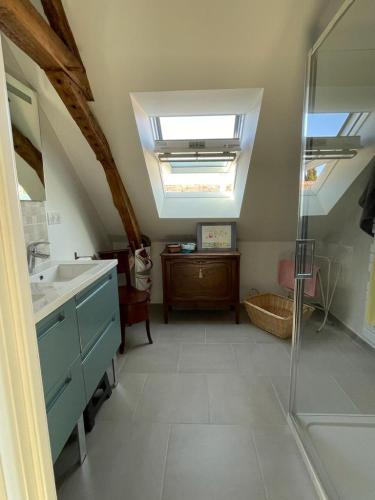 La salle de bains est pourvue d'une douche, d'un lavabo et d'une lucarne. dans l'établissement Gîte La Coulée des Robins, à Continvoir