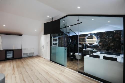 a large kitchen with glass walls and wooden floors at Vila Kace in Korçë