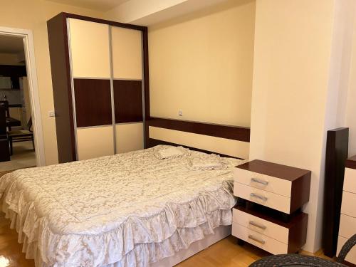 a bedroom with a bed and a dresser in it at Sandras Apartment in Strumica