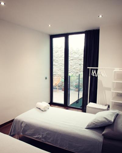a bedroom with a bed and a large window at THE RIVERSIDE LODGE Cozy and spacious apartment in Girona