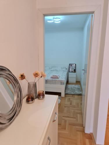 a bathroom with a sink and a mirror and a bedroom at Venus Deluxe Apartment in Strumica