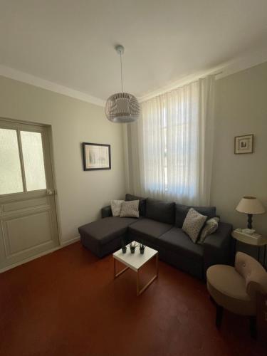 a living room with a couch and a table at La villa des Amandiers in Hyères