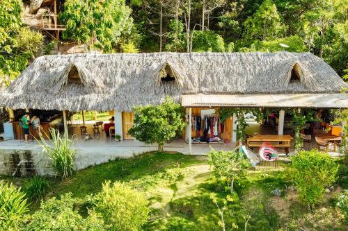 une maison avec un toit de paille et un jardin dans l'établissement The Fort Hostel, à Don Diego