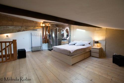 une chambre avec un lit et un parquet dans l'établissement Loft de bernon, à Puisseguin