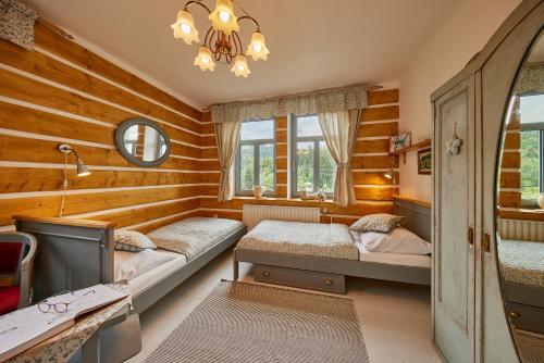 een slaapkamer met 2 bedden en een kroonluchter bij Chalupa v Jizerkach in Albrechtice v Jizerských horách