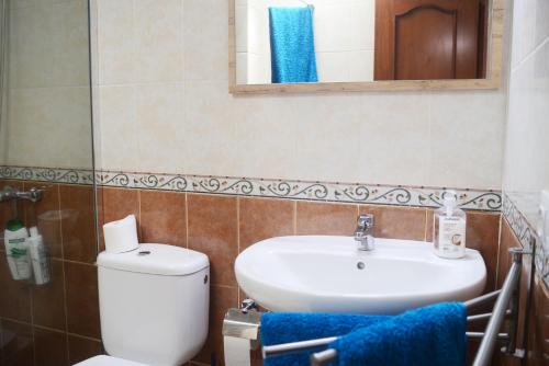 ein Badezimmer mit einem Waschbecken, einem WC und einem Spiegel in der Unterkunft Casa Arya in Cotillo