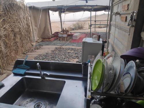 un fregadero de cocina en una caravana con una tienda de campaña en Desert's Edge Eco Tent en Arad