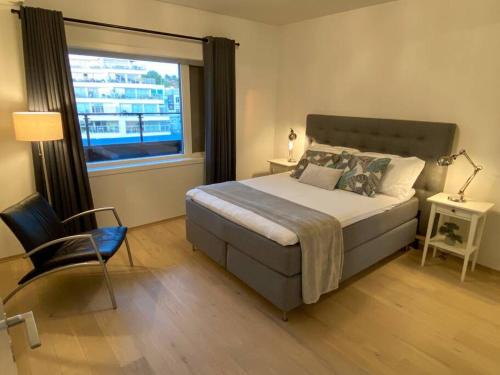 a bedroom with a bed and a window and a chair at Divine Seaview Terrace in Sandnes