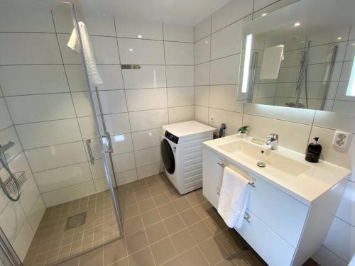 a white bathroom with a sink and a shower at Divine Seaview Terrace in Sandnes