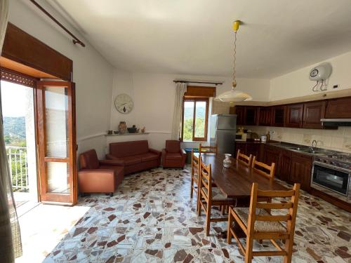 cocina y sala de estar con mesa y sillas en Villa Giordano en Acquavella