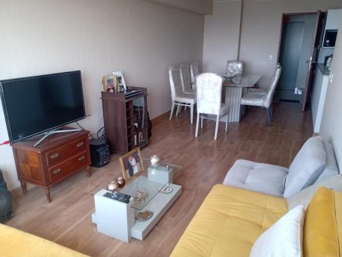 a living room with a couch and a tv and a table at Habitación nueva para persona sola o pareja in Lima