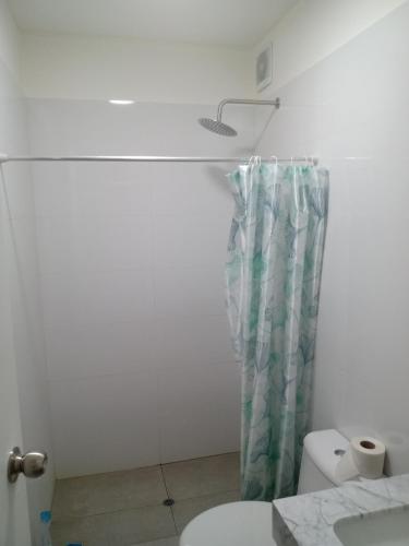 a bathroom with a toilet and a shower curtain at Habitación nueva para persona sola o pareja in Lima