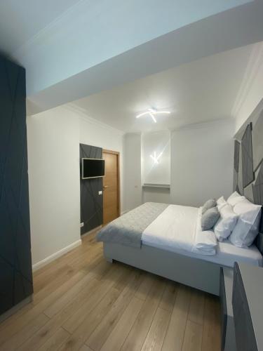 1 dormitorio con 1 cama grande y TV en Elegant Suite - Titan Park, en Bucarest
