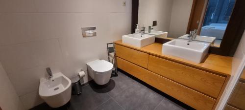 a bathroom with two sinks and a toilet at Kriol Guest House in Praia