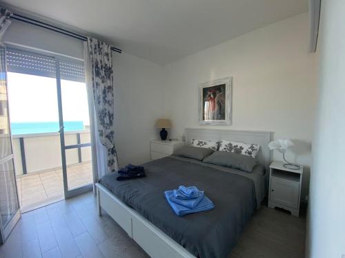 a bedroom with a large bed with a view of the ocean at ATTICO VISTA MARE in Misano Adriatico