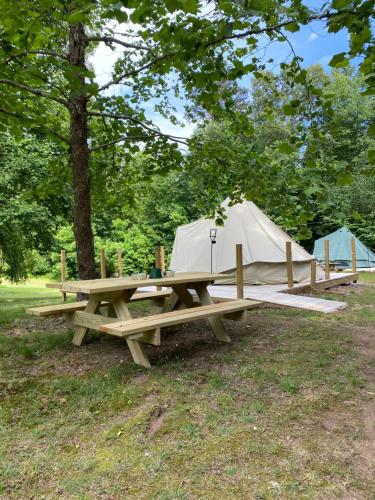 einen Picknicktisch und ein Zelt auf einem Feld in der Unterkunft Wildwood Heart Farm 