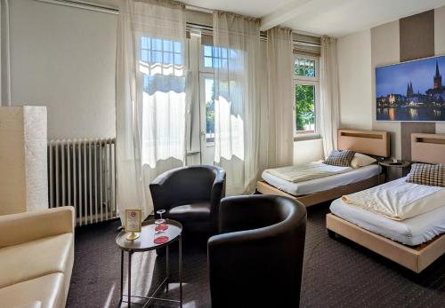 Hotel Schweizerhaus في لوبيك: غرفه فندقيه بسرير واريكه