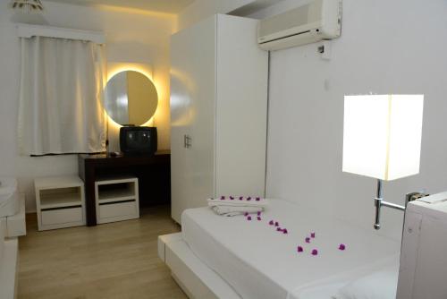 ein weißes Badezimmer mit Badewanne und Spiegel in der Unterkunft Bodrum Park Hotel in Gümbet