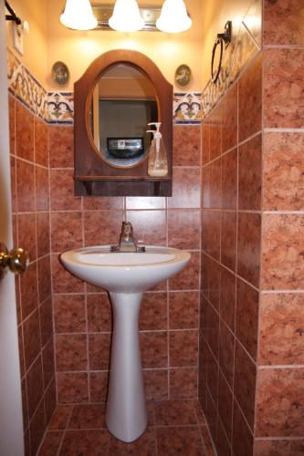 un bagno con lavandino e specchio di O'Brien House a Kingston