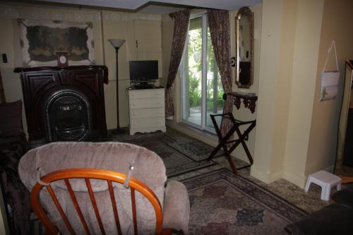 ein Wohnzimmer mit einem Sessel und einem Kamin in der Unterkunft O'Brien House in Kingston