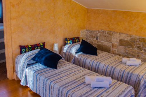 3 camas en una habitación con una pared de piedra en Palo del Colle Ierva Chiain, Guest House, en Palo del Colle