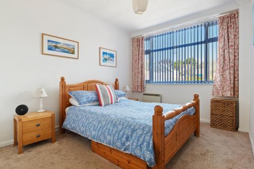 サンダースフットにある2 Harbour Court Saundersfootのベッドルーム1室(木製ベッド1台、窓付)