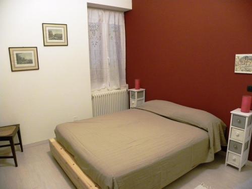 um quarto com uma cama e uma janela com paredes vermelhas em Rivaro Palace em Novi Ligure