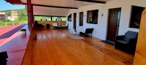 a living room with a wooden floor and chairs at Casa Legrand in Baziaş