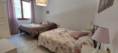 a bedroom with two beds and a table with a lamp at Agriturismo Villa Le Vigne in Montevarchi