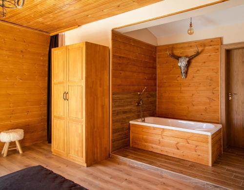 baño con bañera con cabeza de ciervo en la pared en Forest Lux Boutique Villas en Rakitovo