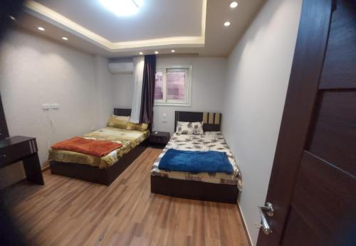a room with two beds in a room with a door at زهرة الدقي in Cairo