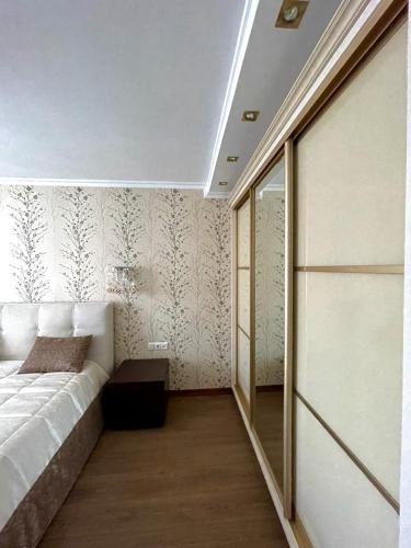 a bedroom with a bed and a wall with wallpaper at Marius Homestay in Chişinău