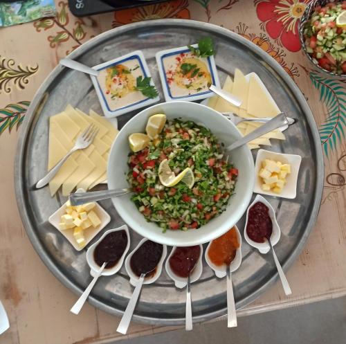 a plate of food with a bowl of food and cheese at Desert's Edge Eco Tent in Arad