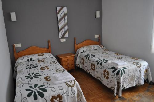 two beds in a small room with at Hostal La Tablada in Navaleno