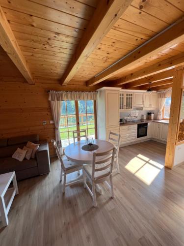 a kitchen and dining room with a table and chairs at Hiška Erika - Wood House Erika in Šoštanj