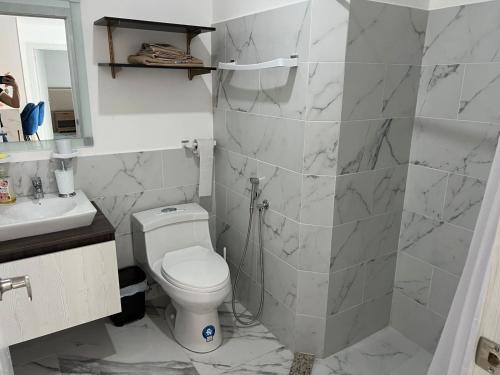 La salle de bains blanche est pourvue de toilettes et d'un lavabo. dans l'établissement Departamento Punta Centinela Torre 3000, Santa Elena, à Punta Blanca