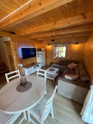 a living room with a table and a couch at Hiška Erika - Wood House Erika in Šoštanj