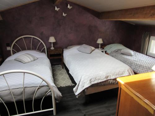 - 2 lits jumeaux dans une chambre aux murs violets dans l'établissement Gite LE MAS FLORANNE, à Méjannes-lès-Alès