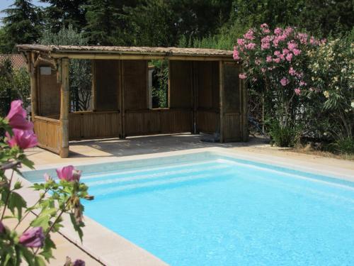 - une piscine avec un kiosque et des fleurs roses dans l'établissement Gite LE MAS FLORANNE, à Méjannes-lès-Alès