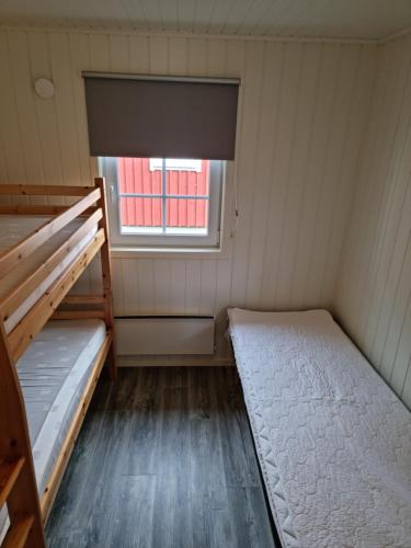 a room with two bunk beds and a window at Hallagårdens stugby in Varberg