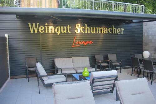 a restaurant with white chairs and a sign on a wall at Weingut Schumacher - mit privatem Saunabereich in Sankt Aldegund