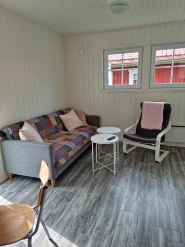 a living room with a couch and a chair at Hallagårdens stugby in Varberg