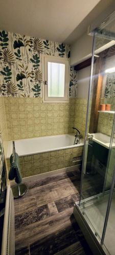 une salle de bain avec une baignoire et un lavabo dans l'établissement Maisonnette Lac de Vassivière, à Beaumont