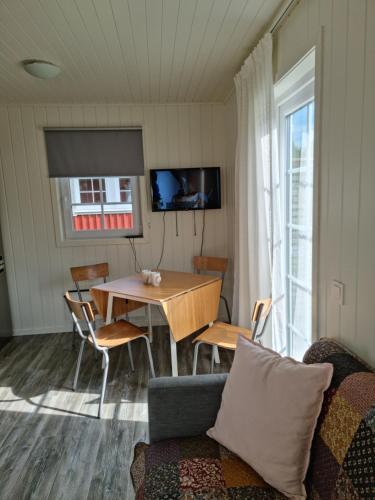 a living room with a table and chairs and a couch at Hallagårdens stugby in Varberg