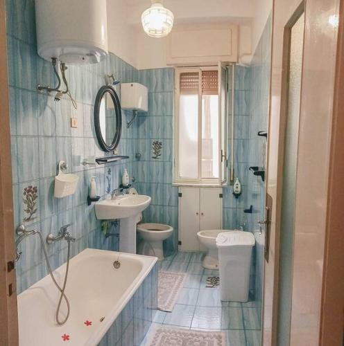 a bathroom with a tub and a toilet and a sink at AleGaia House Minori in Minori