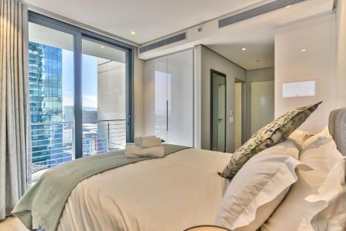 - une chambre avec un grand lit et une grande fenêtre dans l'établissement Elegant apartment in the City, au Cap