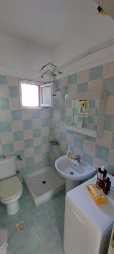 W łazience znajduje się umywalka, toaleta i umywalka. w obiekcie The house of olives w mieście Kallithea