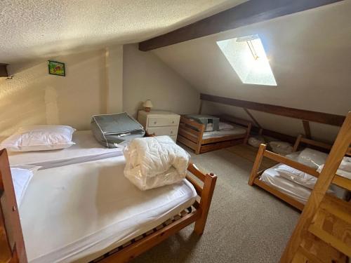 a bedroom with two beds and a skylight at Appartement Morzine, deux pièces, mezzanine, 4 personnes in Morzine