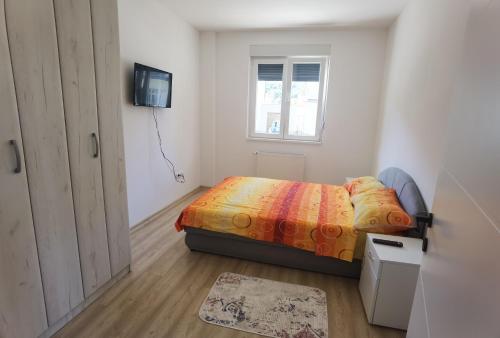 - une petite chambre avec un lit et une fenêtre dans l'établissement Apartman Banja Koviljaca, à Banja Koviljača