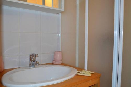 La salle de bains est pourvue d'un lavabo blanc et d'une bougie rose. dans l'établissement Appartement Le Filaterie sous les toits, à Annecy